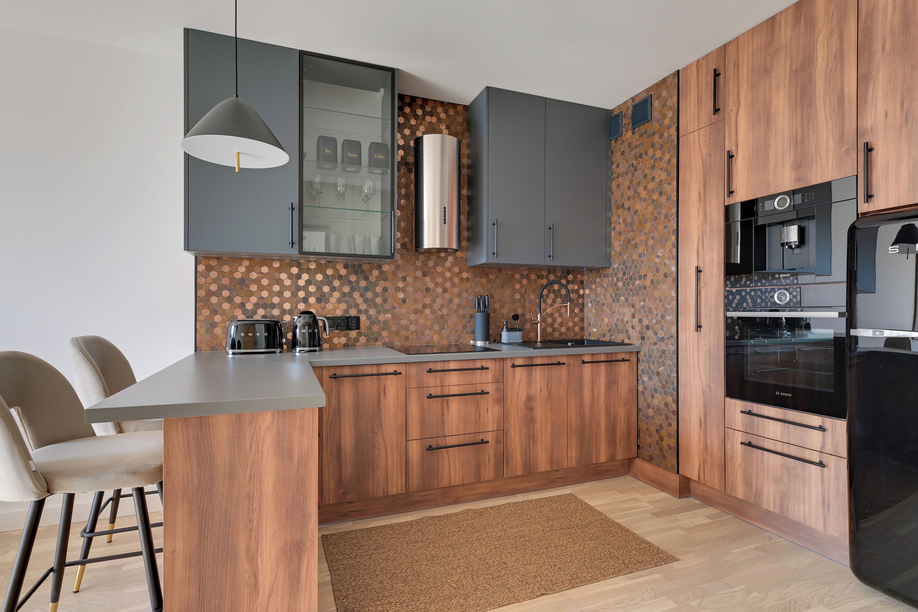A modern kitchen with wooden cabinets, a built-in island, and a coffee machine.