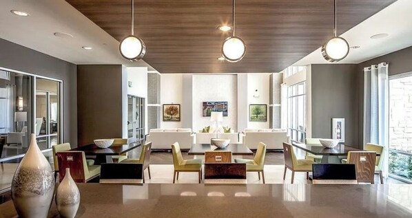 Un comedor moderno con una mesa central, sillas e iluminación colgante.