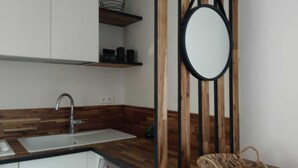 A modern kitchen with a wooden countertop, a white sink, and a black-framed mirror. - HOUSE GARDEN BEACHES WALKS (Saint-Nazaire)