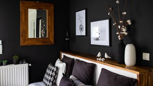 A modern bedroom with a dark wall, a wooden headboard, and a white radiator. - HOUSE GARDEN BEACHES WALKS (Saint-Nazaire)