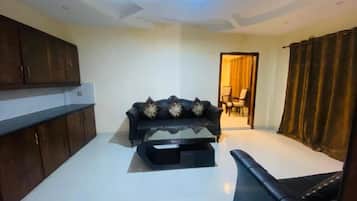 Deluxe Suite | Living area | 32-inch LED TV with cable channels, TV