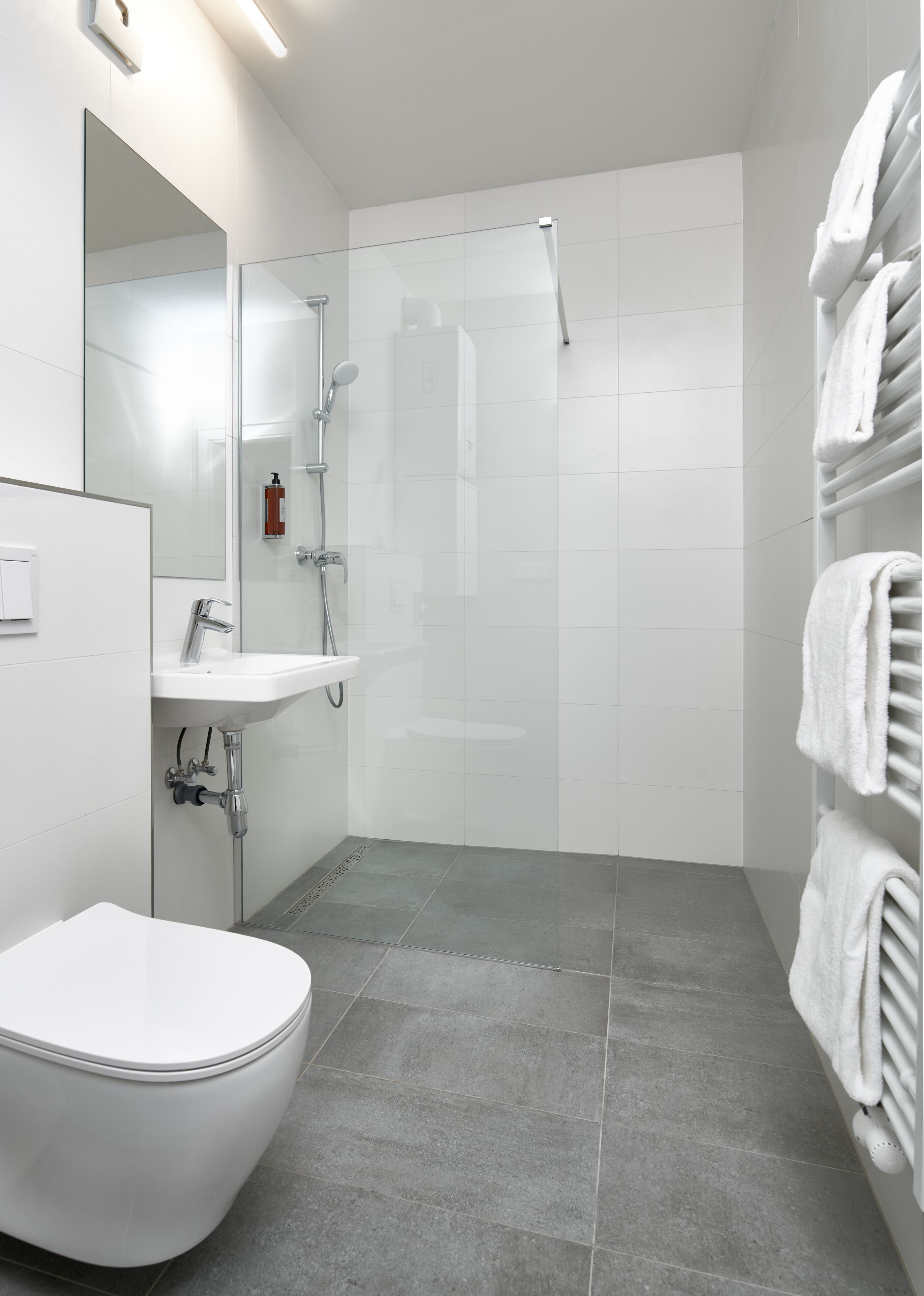 A modern bathroom with a toilet, sink, and shower.
