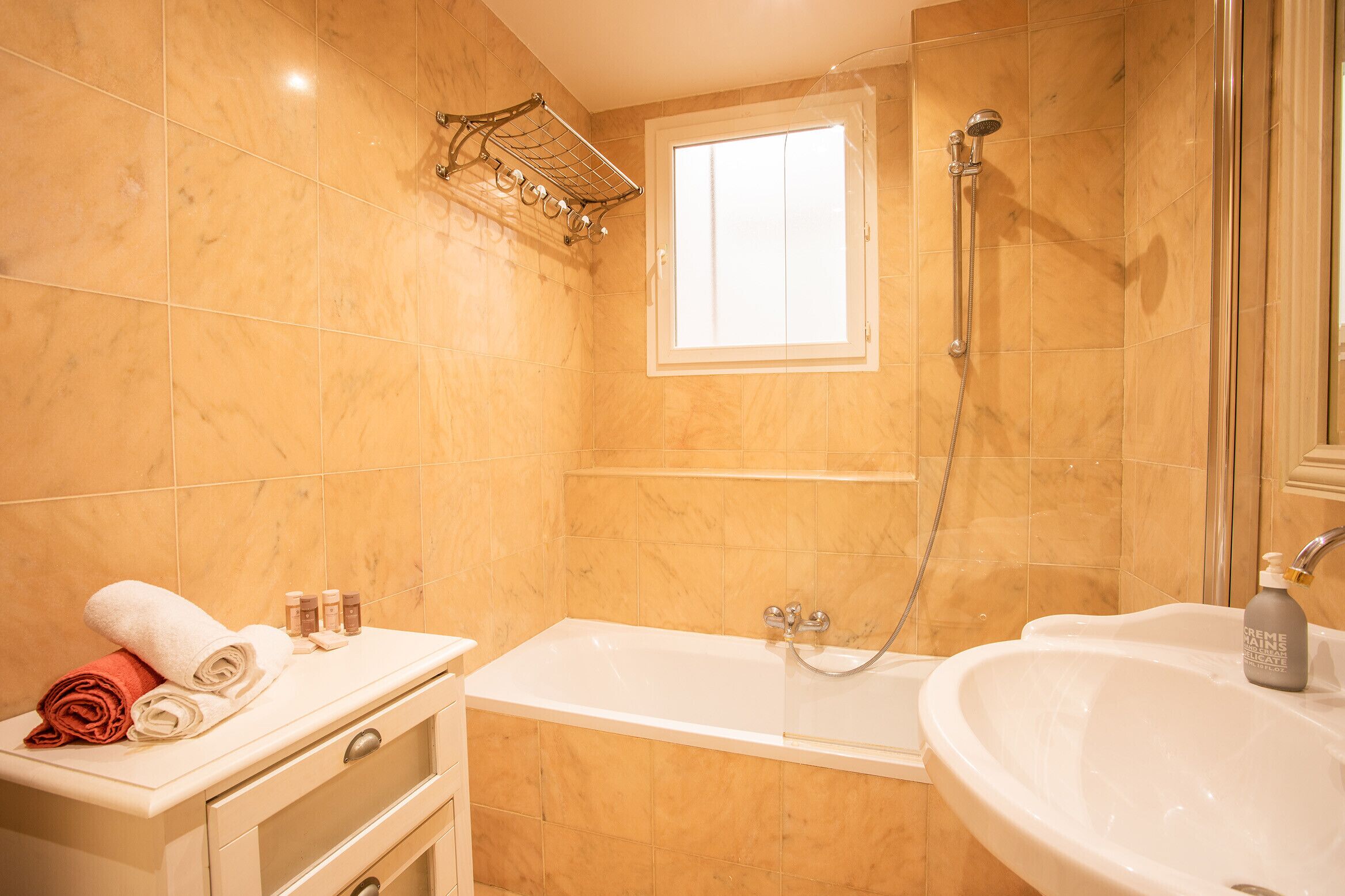 Une salle de bain avec une baignoire, un lavabo et une fenêtre.