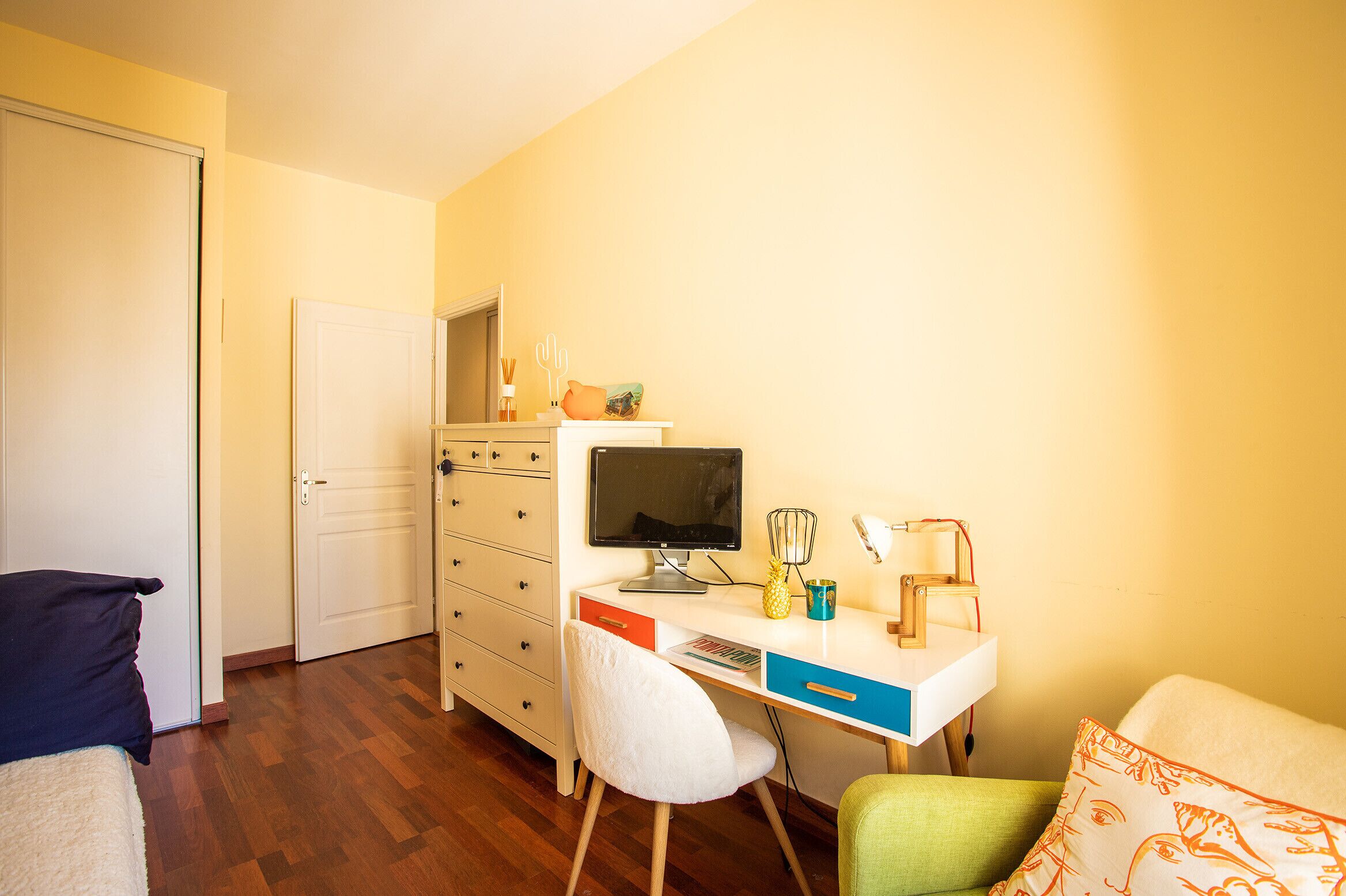 Une petite pièce comprenant un bureau, une chaise et un lit.