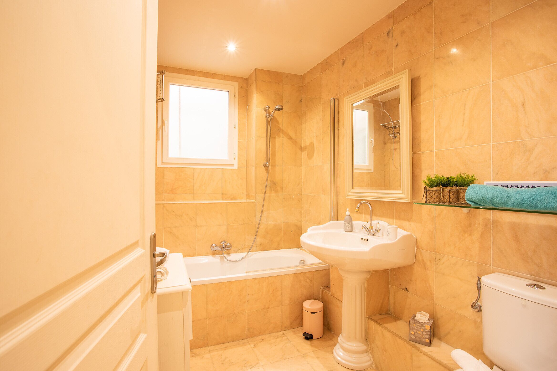 Un baño con bañera, lavamanos e inodoro.
