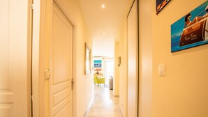 A hotel hallway with a marble floor, a yellow wall, and a framed picture. - LE FOCH AP4244 By Riviera Holiday Homes (Niza)