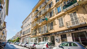 A row of parked cars along a street lined with multi-story buildings, some with balconies and awnings. - LE FOCH AP4244 By Riviera Holiday Homes (Niza)