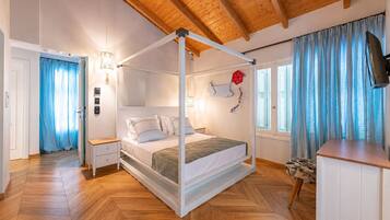 A four-poster bed with white bedding, a wooden ceiling, and a television on the right wall.