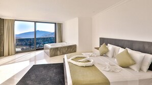 Ein modernes Hotelzimmer mit einem großen Bett, einer Badewanne und Blick auf die Stadt.