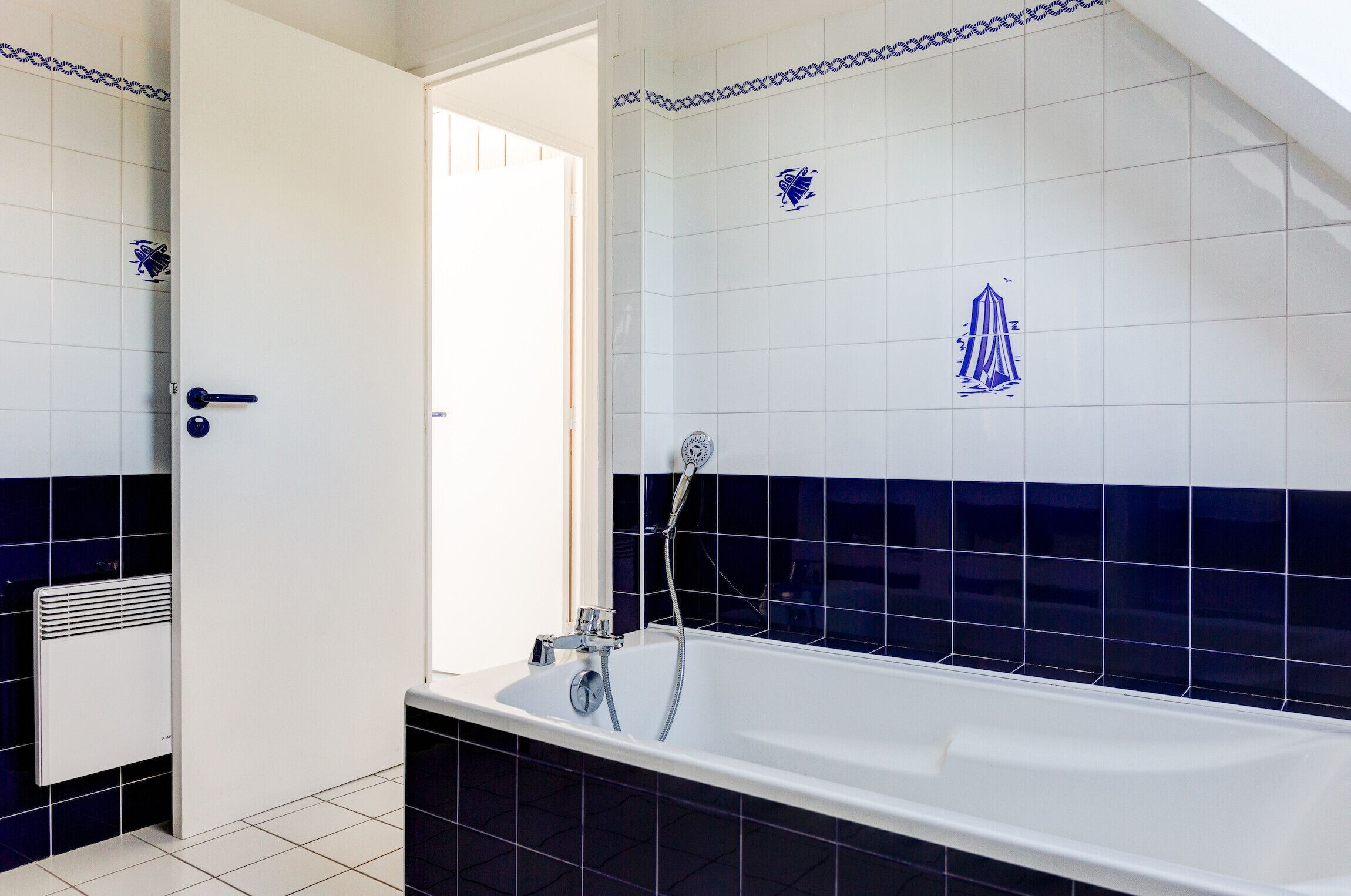 A modern bathroom with a bathtub, a shower, and a white door.