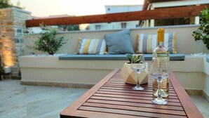A wooden table with a bottle and two wine glasses on it. - Orea Homes (Parga)