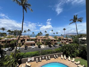 A resort with multiple buildings, a swimming pool with sun loungers, and palm trees. - Kamaole Beach Royale #304, Panoramic Ocean View of Kam Beach #1, Full Kitchen (Kihei)