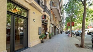 Un bâtiment avec une enseigne indiquant la présence d’un restaurant, une entrée bien visible et un trottoir dallé.