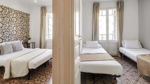 A hotel room with three beds, a patterned wall, and a view through a window. - Sunny 4BD apartment in Sagrada Familia (Barcelona)