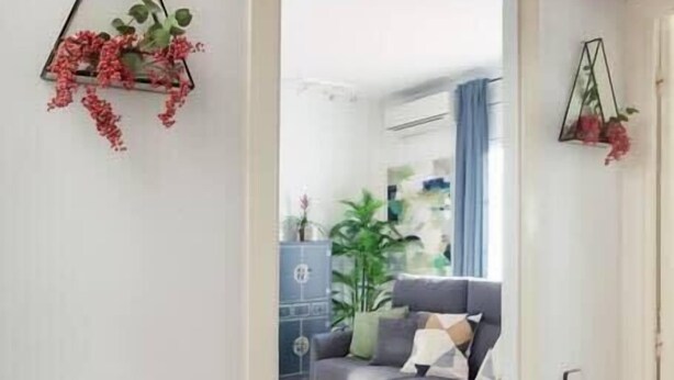 Un salon moderne avec un canapé gris, une table basse et un tapis à motifs.