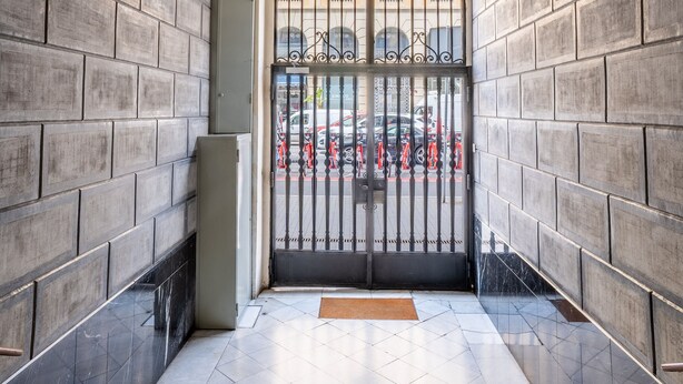 A hallway with a tiled floor, a decorative ceiling, and a gated entrance. - Paseo de Gracia | Classy 3bed 3bath apartment (Barcelona)