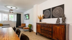 A dining area with a wooden table, chairs, a cabinet, and decorative wall art.