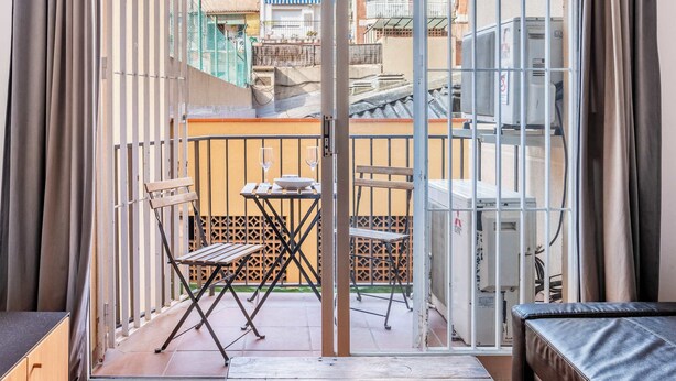 Un balcon avec une table, des chaises et un canapé.