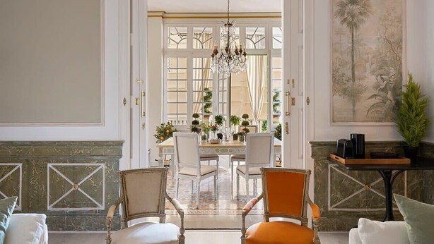 A dining area with a chandelier, a table set for four, and chairs. - Amazing 5Bd for 13 with terrace in Plaza Cataluña (Barcelona)