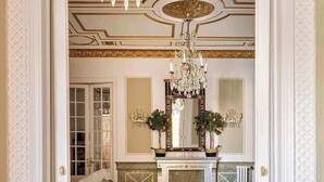 A dining area with a chandelier, a fireplace, and a mirror above the mantel. - Amazing 5Bd for 13 with terrace in Plaza Cataluña (Barcelona)
