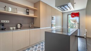 A modern kitchen with built-in appliances, a large island, and a view of the outdoors. - 3-bedroom penthouse with terrace in Eixample (Barcelona)