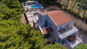 A two-story building with a swimming pool, outdoor seating, and a balcony. - Villa Brela Apartment 1 (Brela)