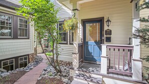 A house with a blue door, a stone pillar, and a small tree in the front yard. - Ridge Street Chalet B 2 Bedroom Townhouse by RedAwning (Breckenridge)