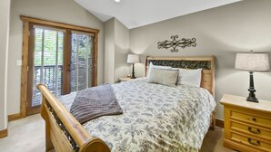 A bedroom with a bed, wooden headboard, ceiling fan, and a nightstand with a lamp. - Ridge Street Chalet B 2 Bedroom Townhouse by RedAwning (Breckenridge)