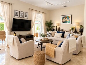 A living room with a flat-screen TV, two sofas, a coffee table, and a TV stand.