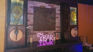 A bar area with a neon sign, decorative glass panels, and a brick wall backdrop. - Waterfront 4 bedroom. Discount available for extended or monthly rentals! (Slidell)