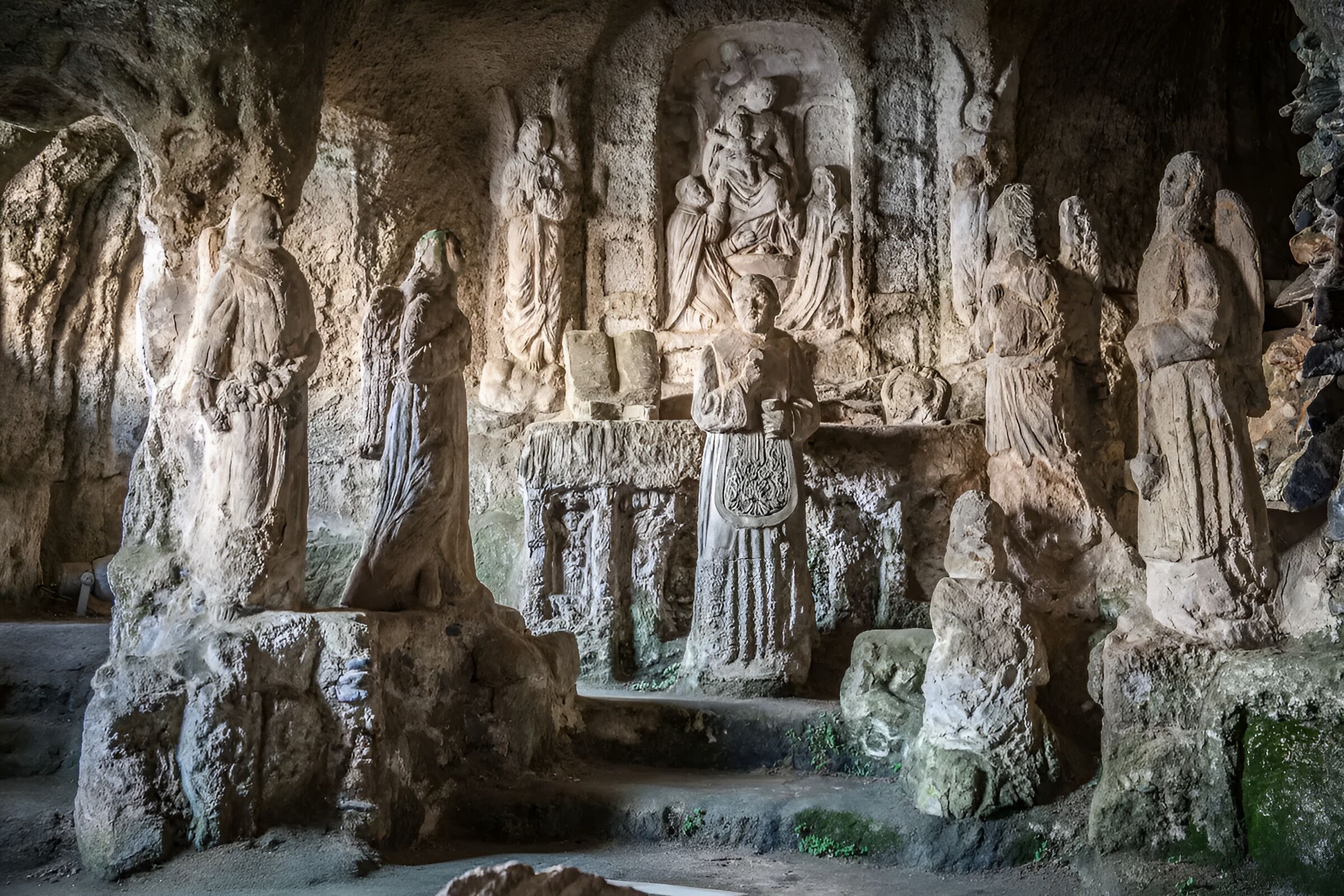Eine Höhle mit alten Steinhauptwerken und Statuen.