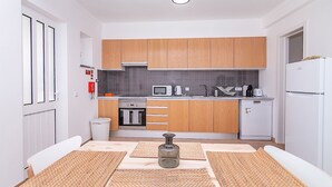 Una cucina compatta con mobili in legno, un forno a microonde, una macchina per il caffè e un'lavastoviglie.