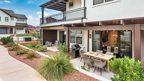 A modern two-story house with a patio, outdoor seating, and a barbecue area. - Red Mountain Springs, GORGEOUS VIEWS, GREAT COMMUNITY POOL! (Santa Clara)