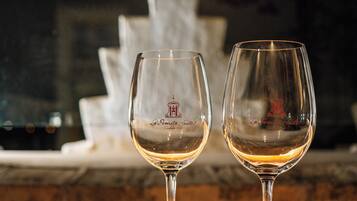 Dos copas de vino con una fuente al fondo.