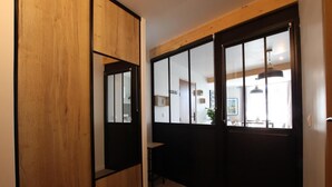 A room with a wooden wardrobe, a sliding glass door, and a view of a dining area.