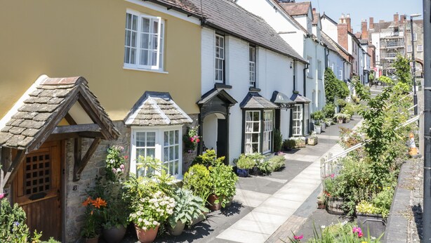 A narrow street lined with traditional houses, each with distinct architectural features like pitched roofs and white window frames. - 55 Corve Street (Ludlow)