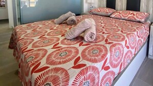 Ein Schlafzimmer mit einem Bett, einem Gemälde und einer Glastür.