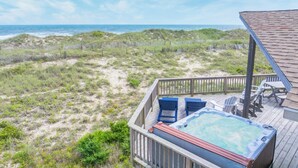 A wooden deck with a hot tub, lounge chairs, and a view of the beach and ocean. - Oceanfront Dog Friendly Home w/ Hot Tub, Smart TVs, Community Walkway to Beach (Hatteras)