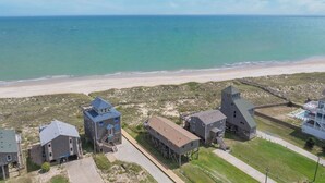 An aerial view of a coastal area with multiple buildings, including a lighthouse, a beach, and a boardwalk. - Oceanfront Dog Friendly Home w/ Hot Tub, Smart TVs, Community Walkway to Beach (Hatteras)