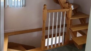 A wooden staircase with white balusters and a handrail, leading to an upper floor. -  Charming  Cozy  Waterfront Cottage  (Val Des Bois)