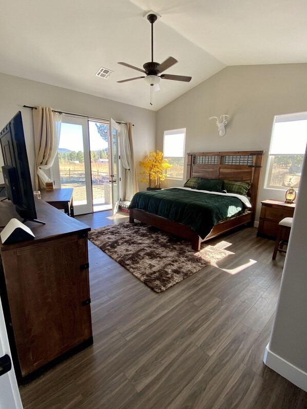 A bedroom with a bed, a desk, a ceiling fan, and a view of the outdoors. - *** Double MASTER Cabin *** Walk to Lake and Golf Course (Williams)
