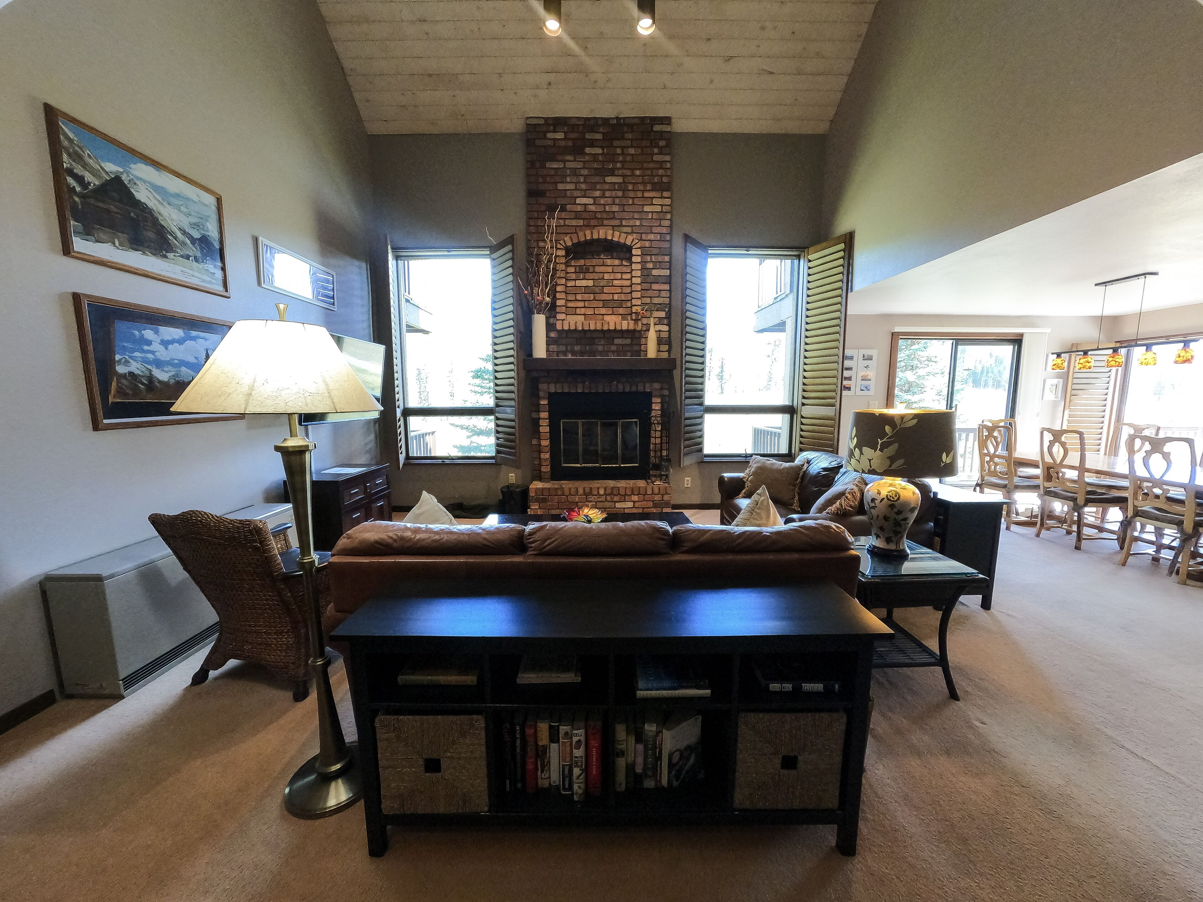 A cozy living room with a fireplace, comfortable seating, and a bookshelf.
