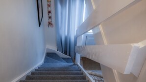 A staircase with a handrail and a wall-mounted decorative item.