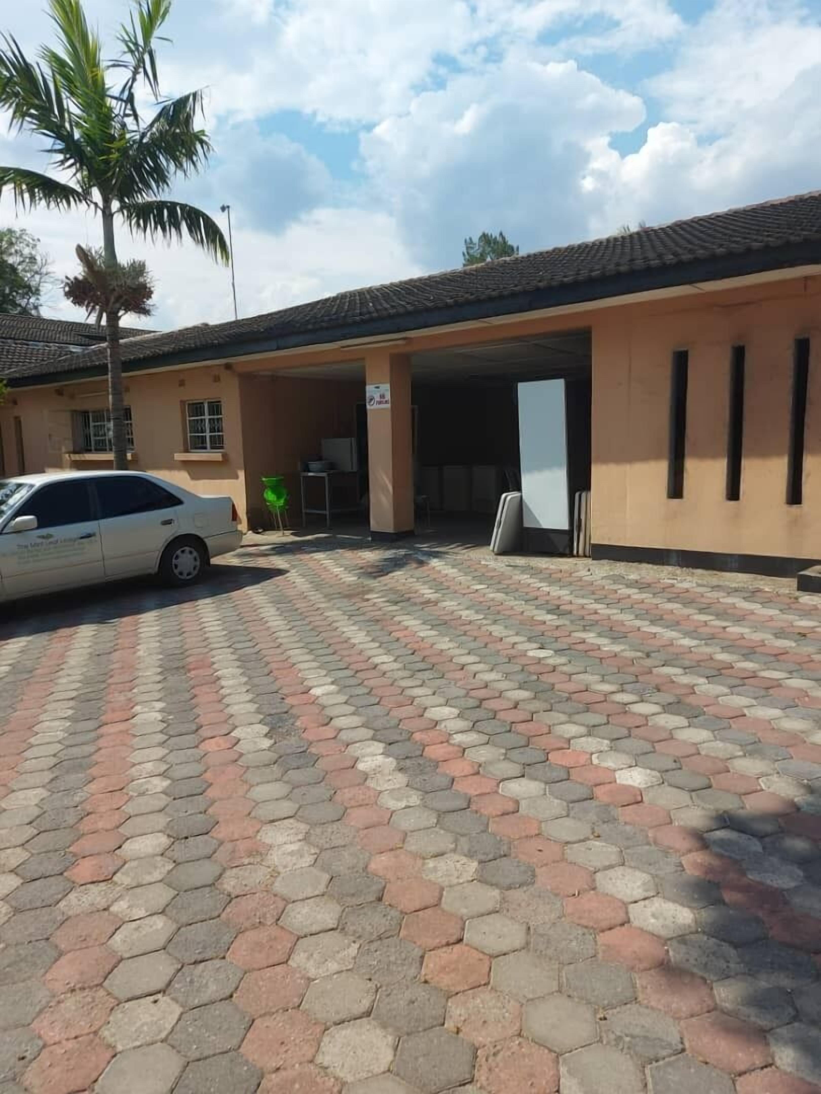 A building with a tiled roof and a paved hexagonal tile driveway.