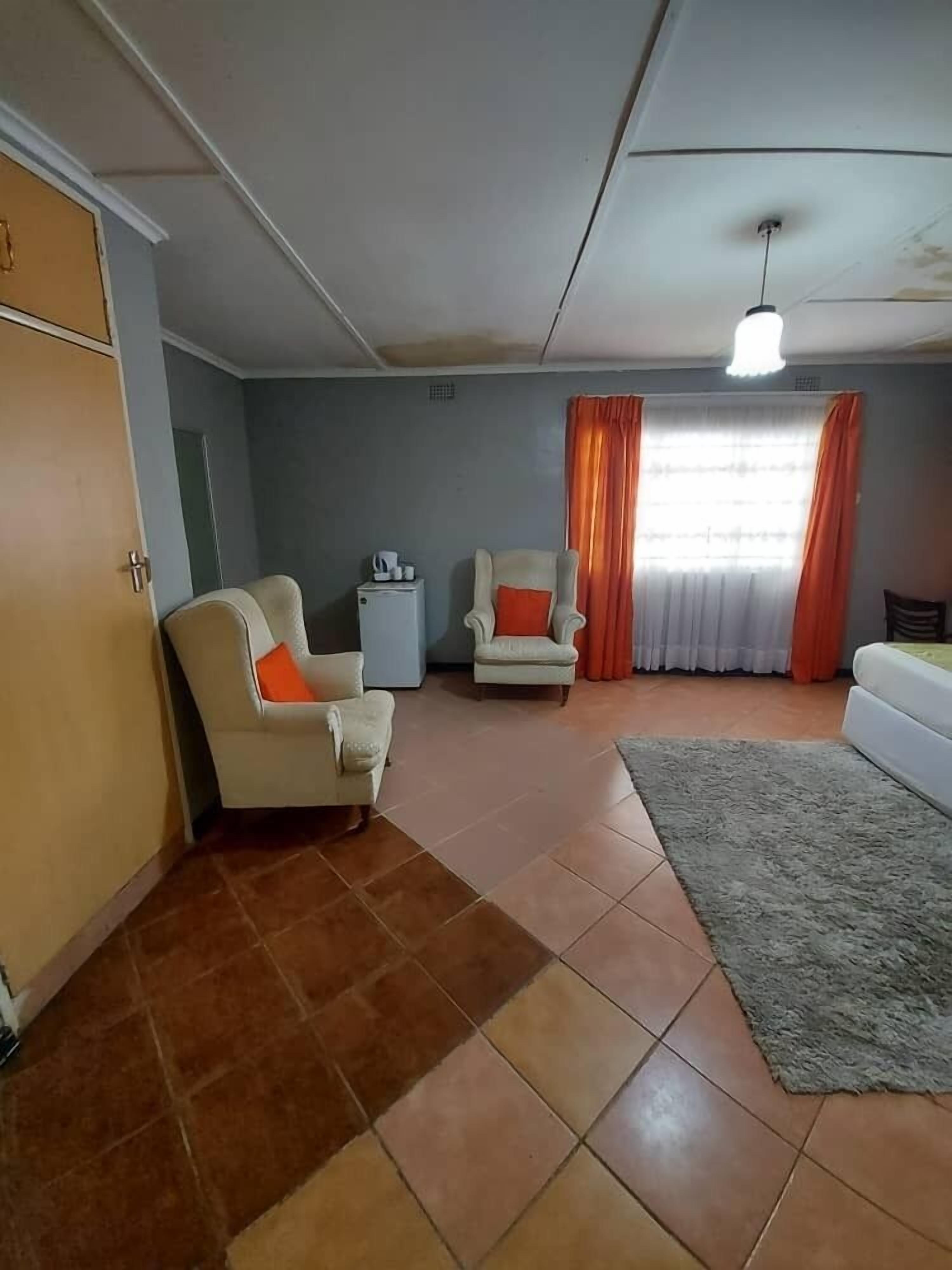 A room with a sofa, two armchairs, a small table, and a cabinet.