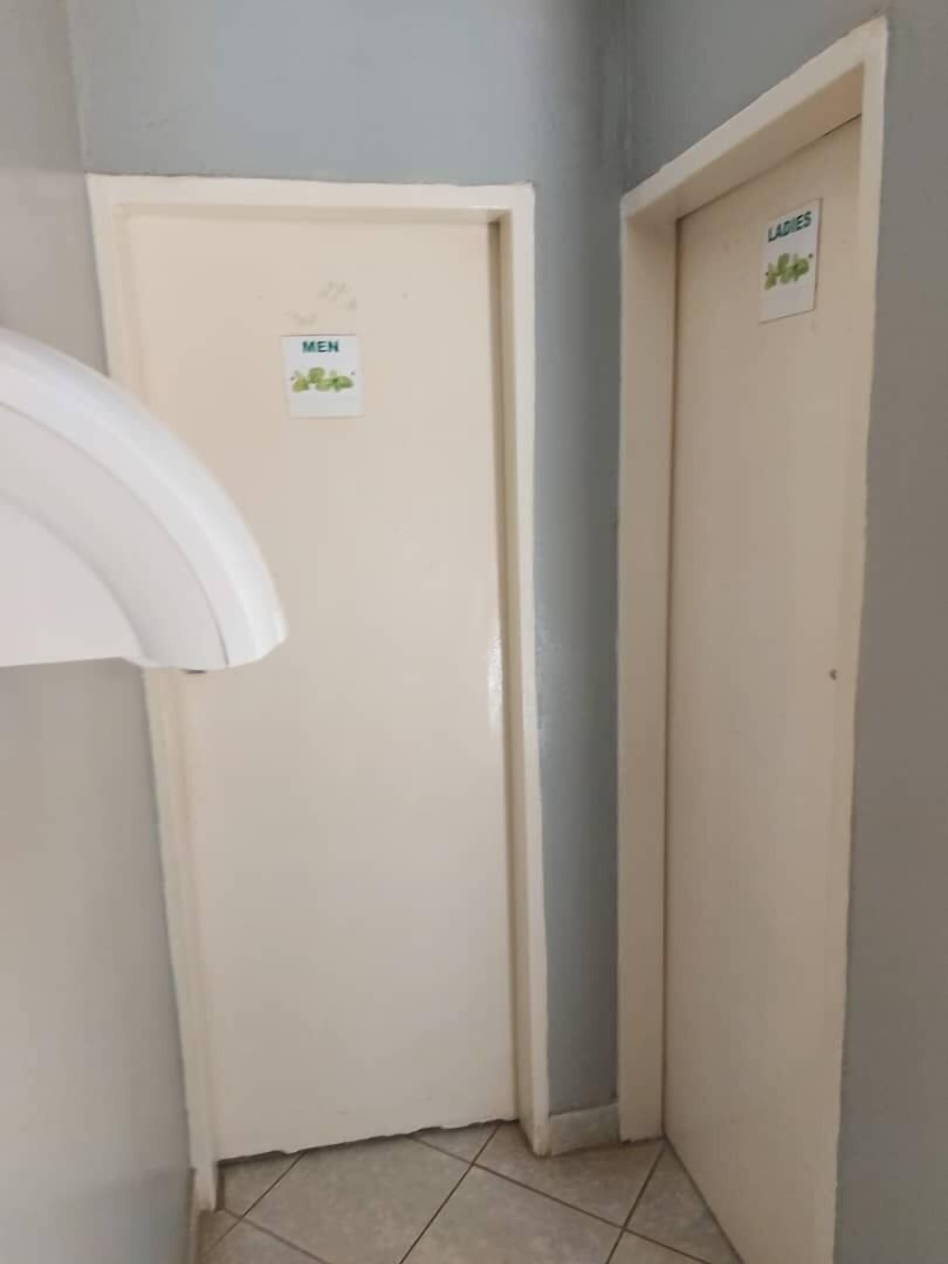A hallway with a white door labeled "MEN" and another door labeled "LADIES".