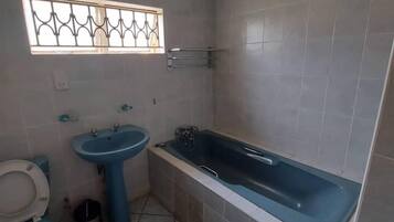 A small bathroom with a toilet, sink, and bathtub.