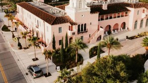 A building with a pink facade, arched windows, and a central tower. - NEW Steps to Downtown • 7 Mins to Beach + Parking (New Port Richey)