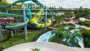 A water park with multiple slides and pools, surrounded by greenery. - NEW Steps to Downtown • 7 Mins to Beach + Parking (New Port Richey)