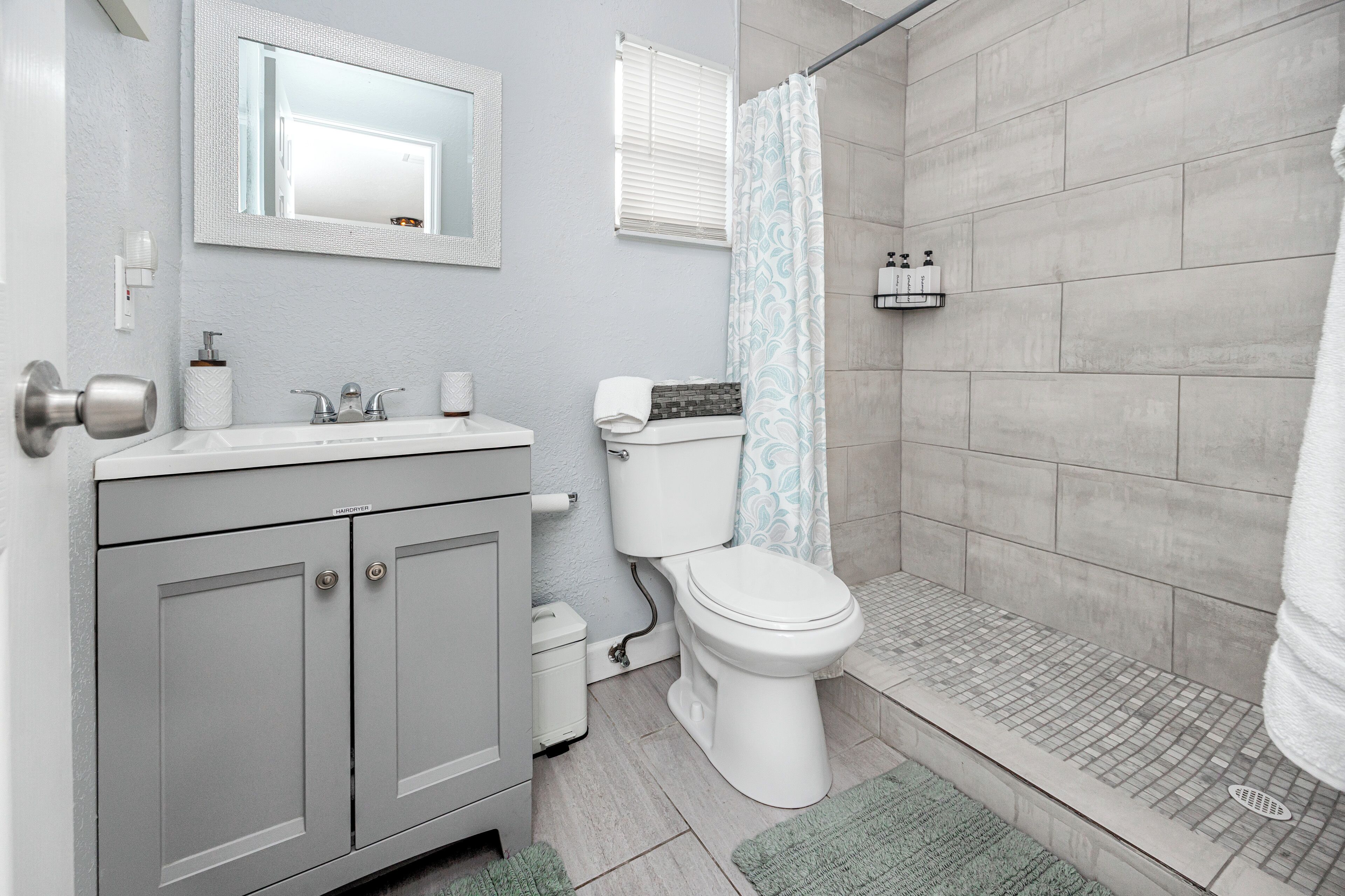 A bathroom with a toilet, sink, and shower area.